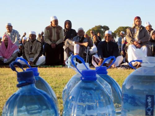 Muslims site before bottles of water